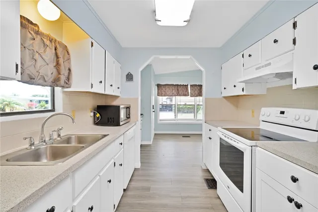 a kitchen with a sink a stove and cabinets