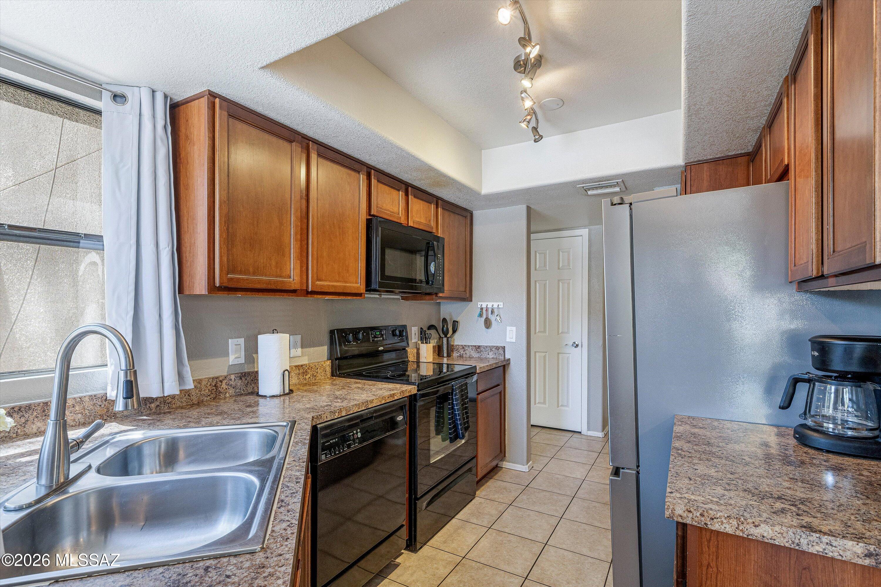 5855 North Kolb Road, Unit 8106 Tucson, AZ 85750 - Photo 8 of 34 a kitchen with granite countertop a sink stainless steel appliances and cabinets