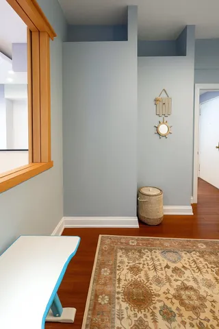 a view of an empty room with a window and wooden floor