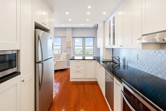a kitchen with stainless steel appliances granite countertop a refrigerator and a sink
