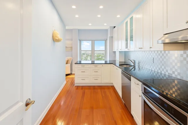 a kitchen with a sink and wooden floor