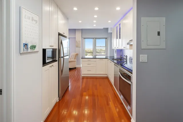 a kitchen with stainless steel appliances a refrigerator and a wooden floor