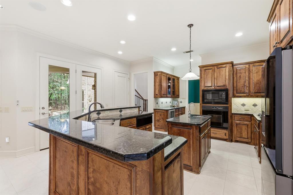 970 Crystal Cove Oak Point, TX 75068 - Photo 10 of 40 a open kitchen with stainless steel appliances granite countertop a kitchen island a stove a refrigerator a sink a dining table and chairs with wooden floor