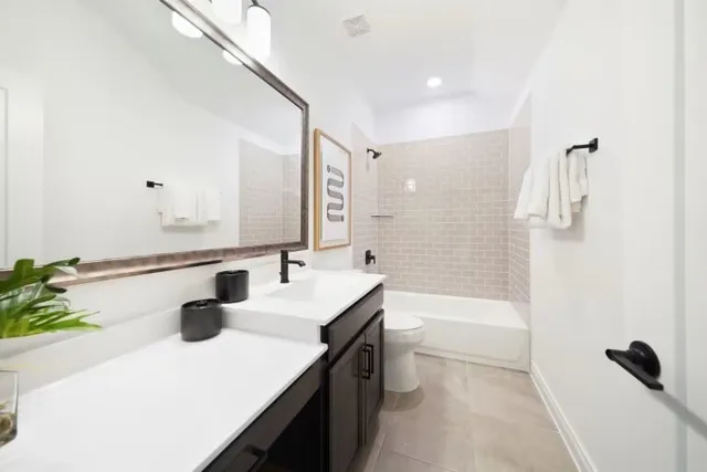 a bathroom with a sink a toilet a mirror and shower