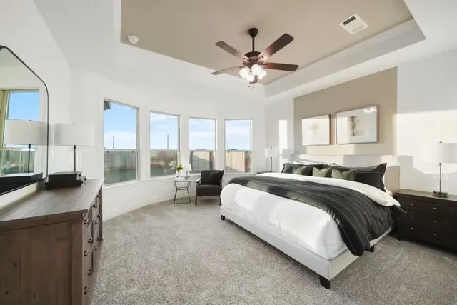 a spacious bedroom with a large bed and a chandelier
