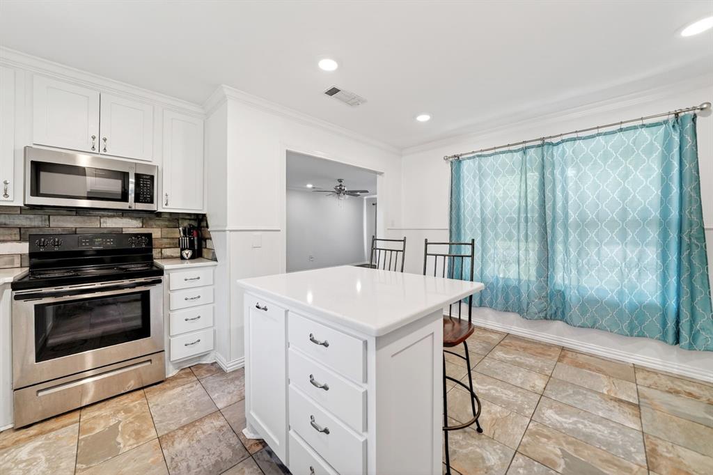 505 Laurel Road Athens, TX 75751 - Photo 11 of 32 Kitchen featuring white cabinetry, stainless steel appliances, a center island with a white countertop, and tile flooring