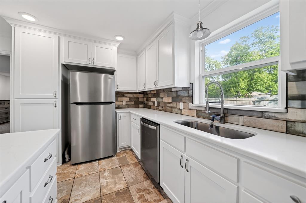 505 Laurel Road Athens, TX 75751 - Photo 16 of 32 Kitchen featuring white shaker cabinetry, stainless steel appliances, a multi-tone subway tile backsplash, and light-tone countertops