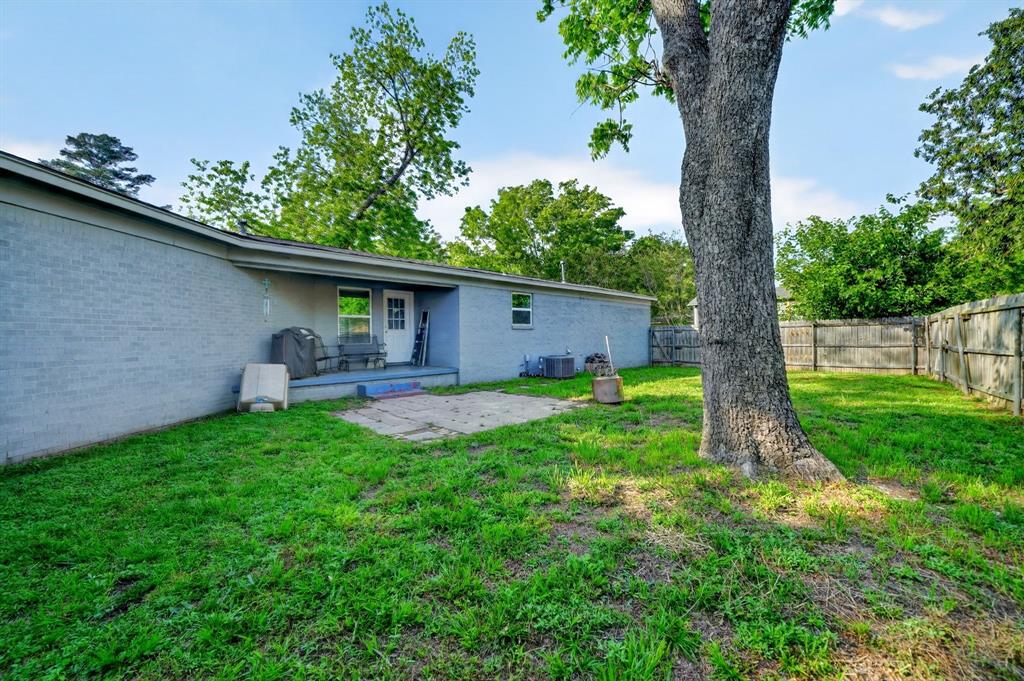 505 Laurel Road Athens, TX 75751 - Photo 29 of 32 Expansive backyard featuring a large tree, a privacy fence, and an outdoor patio with a covered porch