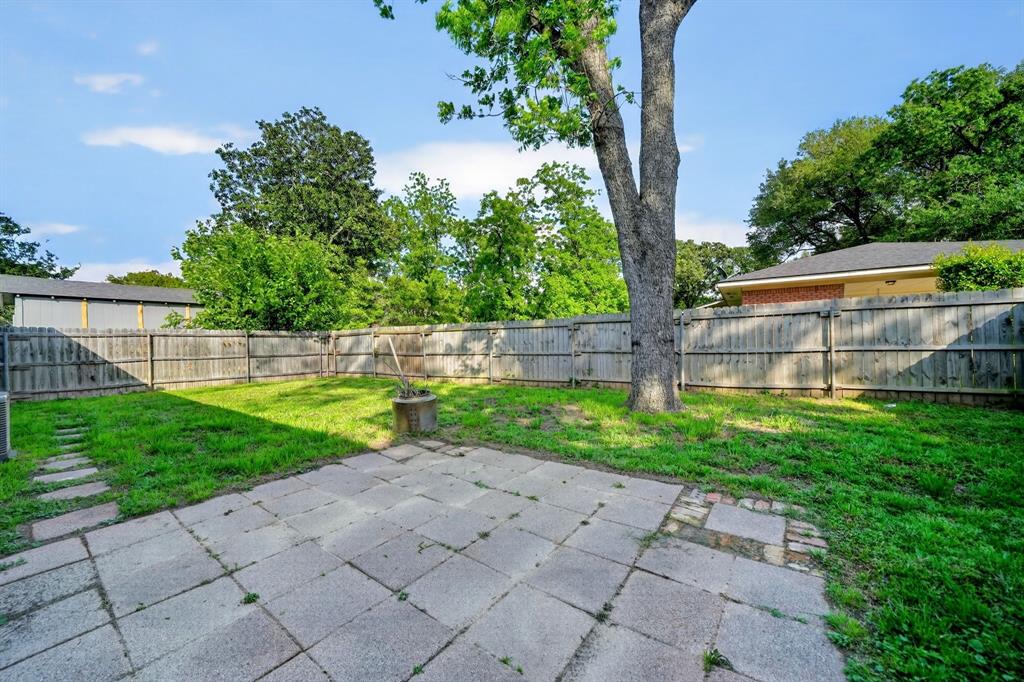 505 Laurel Road Athens, TX 75751 - Photo 31 of 32 Expansive backyard featuring a large paved patio, a grassy area, mature perimeter trees, and a wooden privacy fence