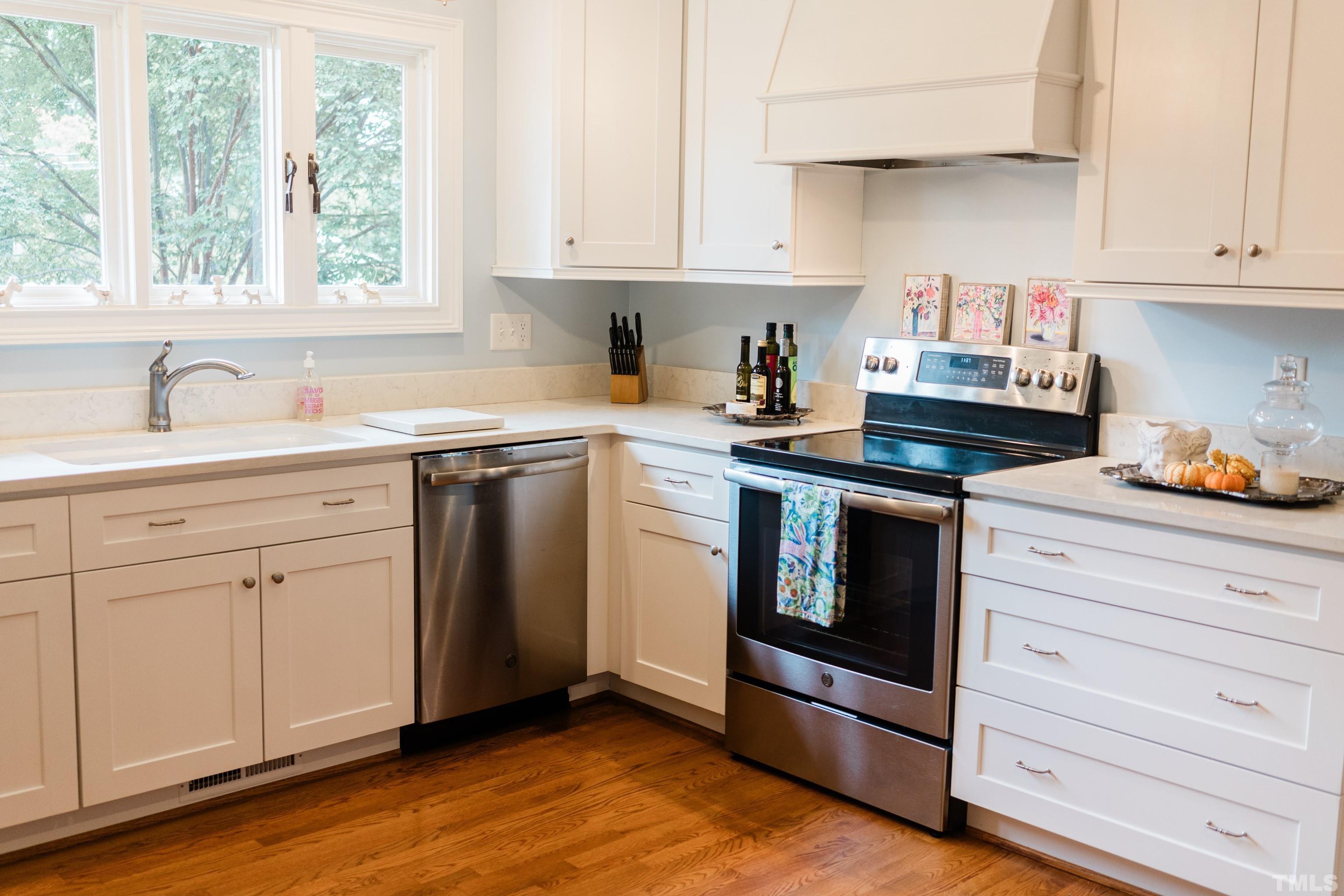 423 East Rowan Street Raleigh, NC 27609 - Photo 5 of 20 a kitchen with white cabinets stainless steel appliances and sink
