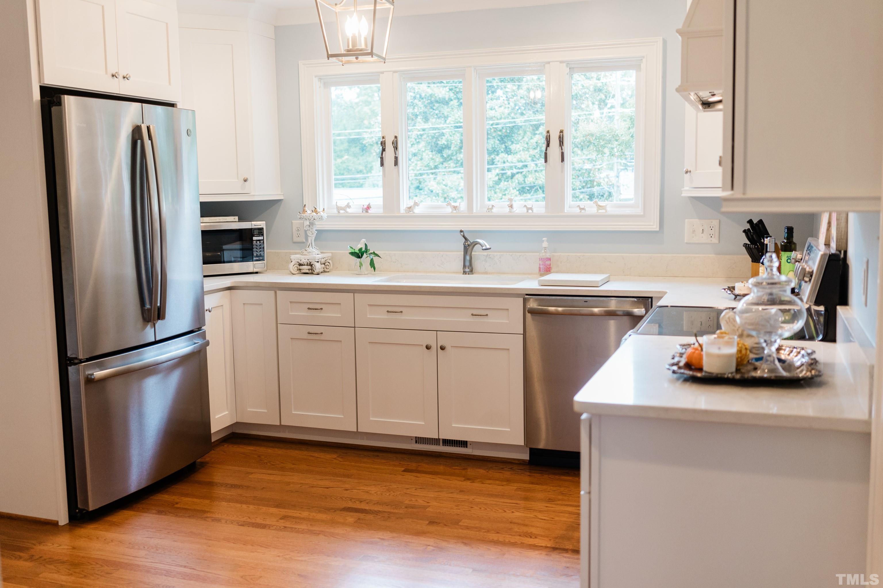 423 East Rowan Street Raleigh, NC 27609 - Photo 6 of 20 a kitchen with stainless steel appliances a refrigerator a sink a stove a microwave and cabinets