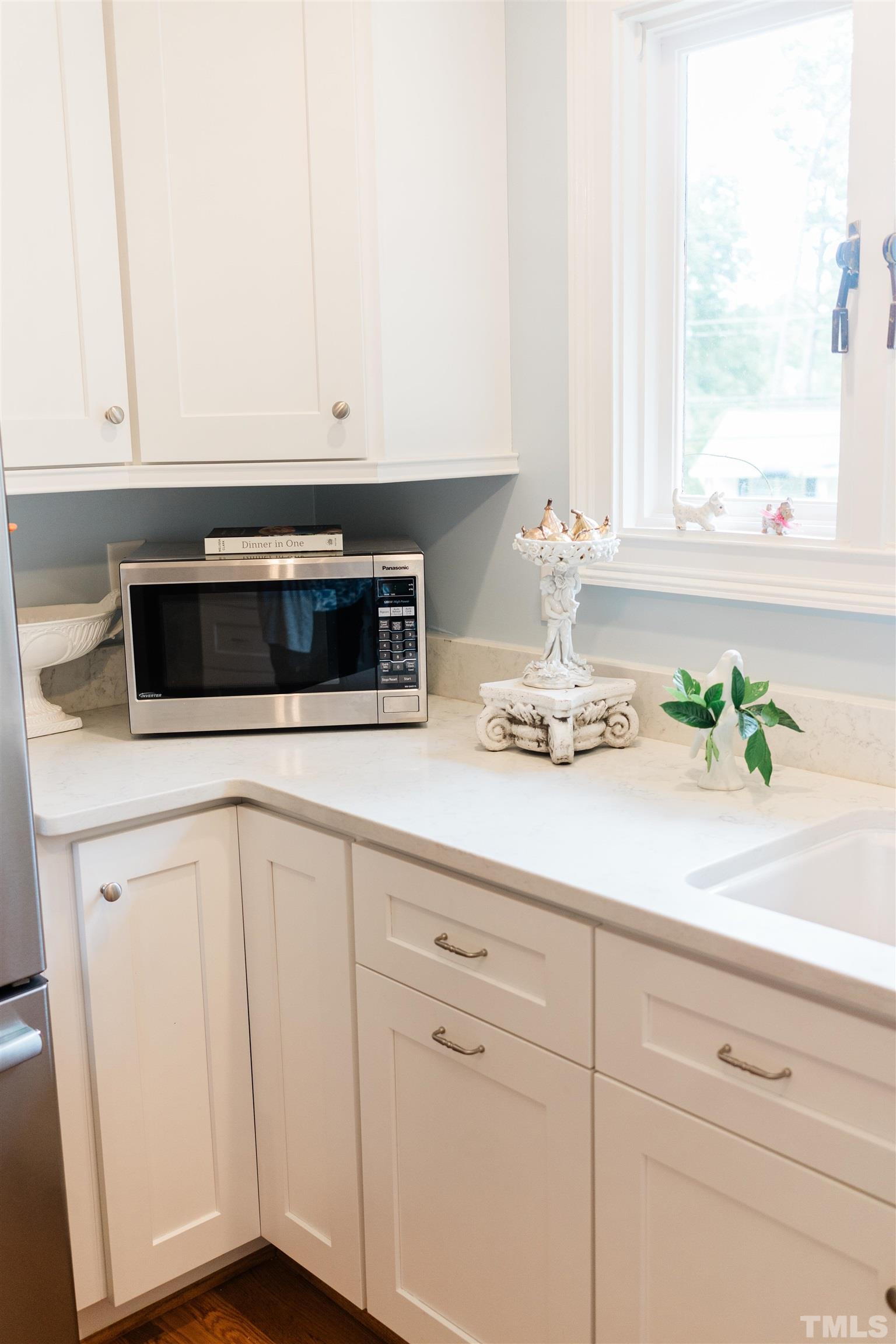 423 East Rowan Street Raleigh, NC 27609 - Photo 8 of 20 a kitchen with stainless steel appliances white cabinets and a potted plant