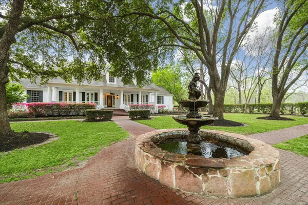 a view of a house with fountain in front of house