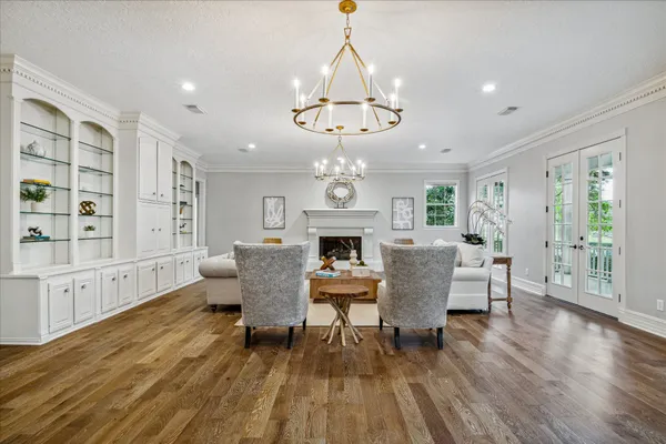 a living room with furniture kitchen view and a chandelier