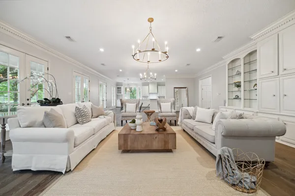 a living room with furniture or chandelier and a wooden floor