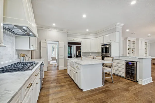 a dining room with wooden floor a chandelier a wooden table and chairs