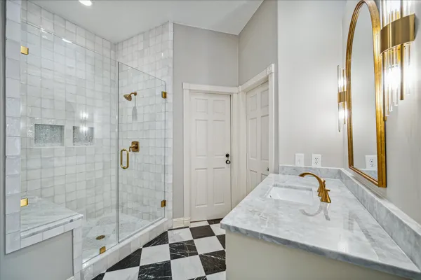 a bathroom with a sink and mirror with bathtub