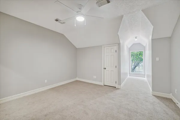 an empty room with windows and fan
