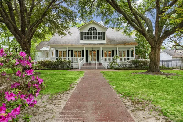 a front view of a house with a garden and trees
