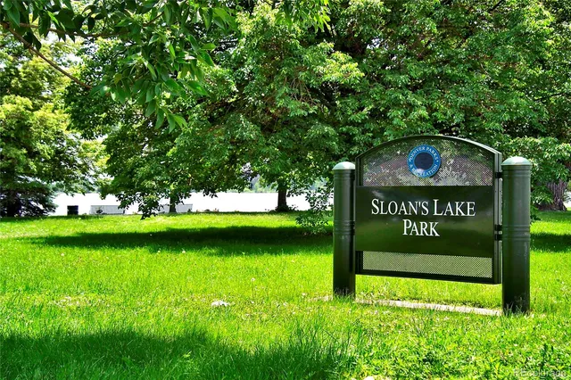 a view of a street sign under a large tree