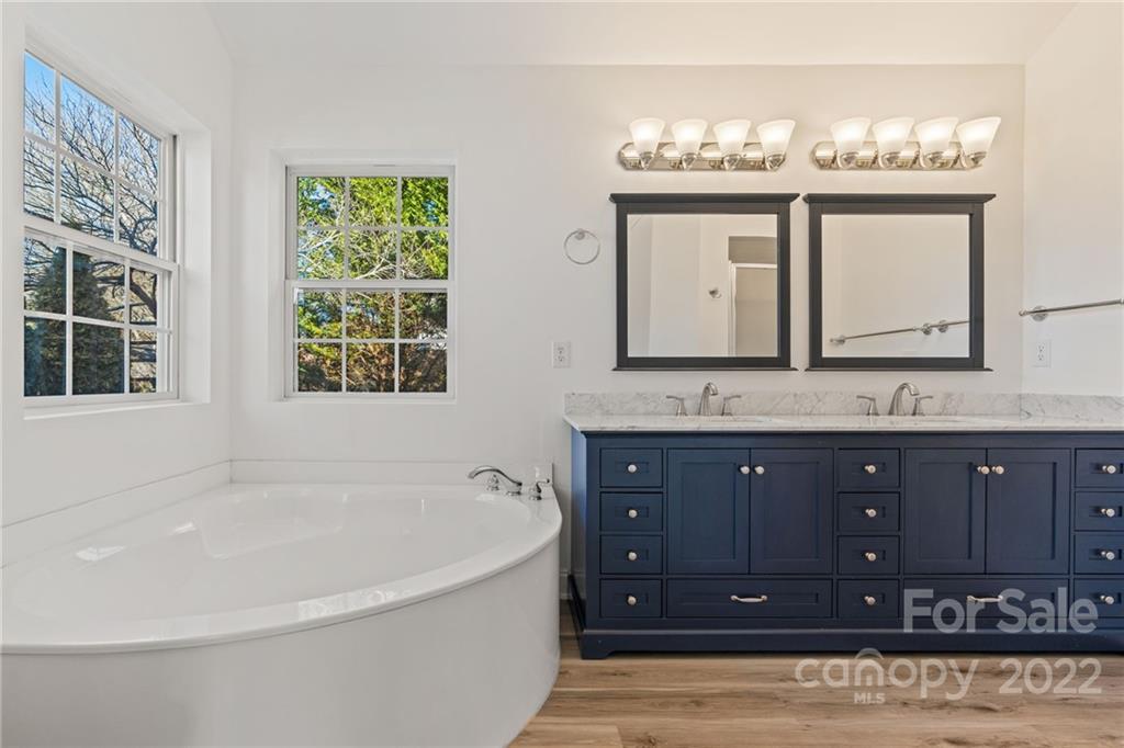 38 Grove End Road, Unit LOT/2 Fletcher, NC 28732 - Photo 21 of 39 a bathroom with a tub a double vanity sink and a large mirror