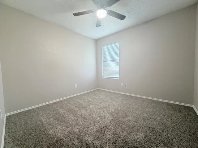 a view of an empty room and a ceiling fan