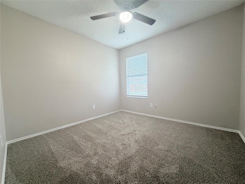 1826 Trailview Drive Terrell, TX 75160 - Photo 15 of 27 an empty room with a chandelier fan and windows