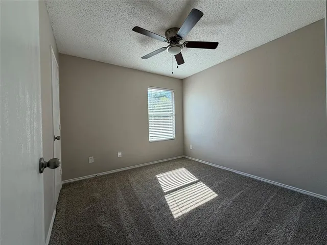 en empty room with ceiling fan and window