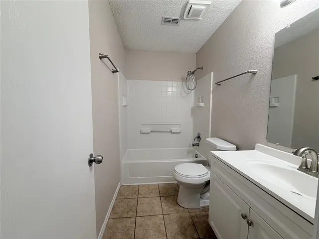 a bathroom with a toilet a sink a mirror and vanity