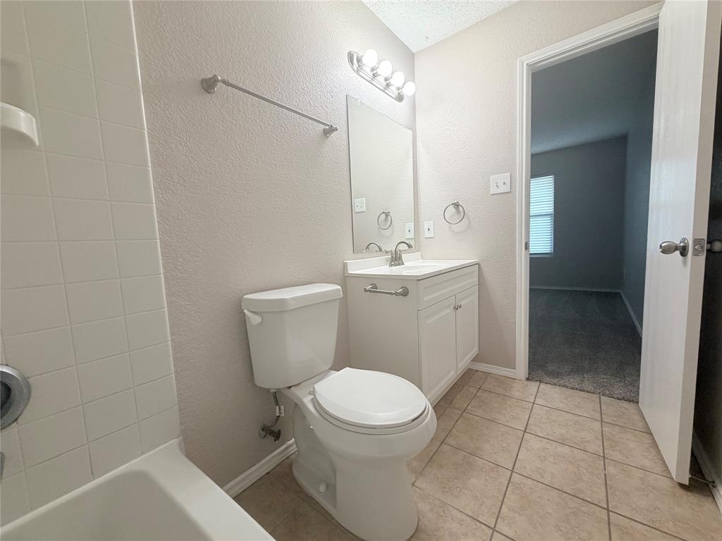 1826 Trailview Drive Terrell, TX 75160 - Photo 23 of 27 a bathroom with a toilet a sink a mirror and vanity