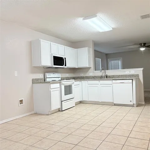 a kitchen with cabinets stainless steel appliances and a sink