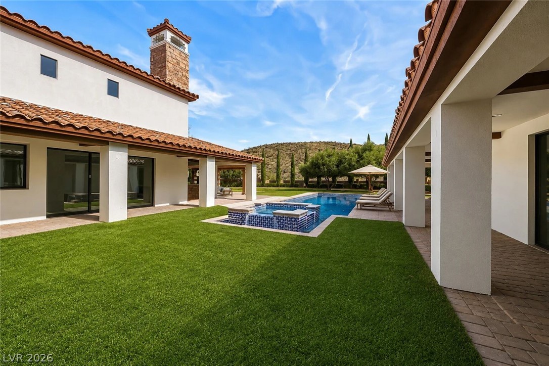 1140 Julie Road Henderson, NV 89002 - Photo 4 of 38 A private backyard oasis with lush green grass and a sparkling pool & spa invites relaxation.