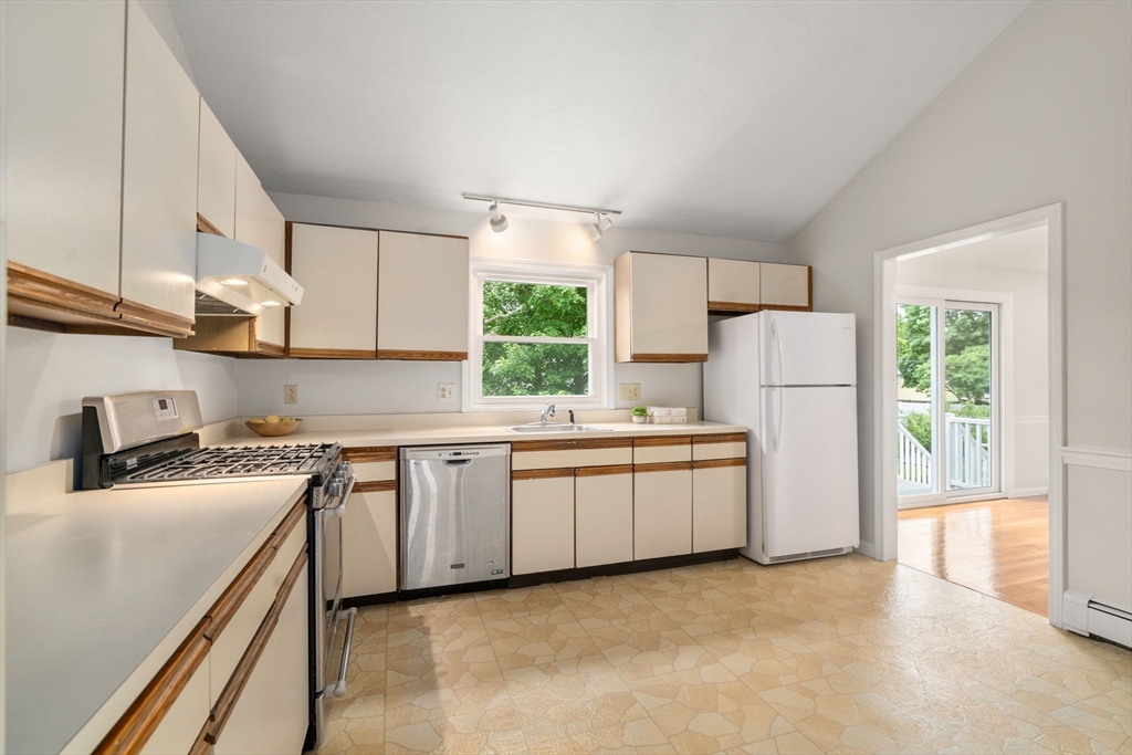 16 Shelley Road Arlington, MA 02476 - Photo 8 of 30 a kitchen with stainless steel appliances granite countertop a sink a stove a refrigerator a microwave a sink and white cabinets with wooden floor