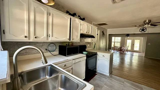 a kitchen with stainless steel appliances granite countertop a sink a stove and cabinets