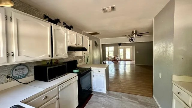 a kitchen with stainless steel appliances granite countertop a stove refrigerator and cabinets