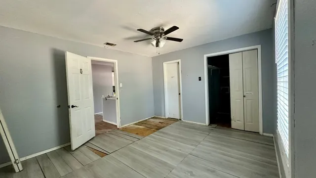 a view of a livingroom with a chandelier fan and wooden floor