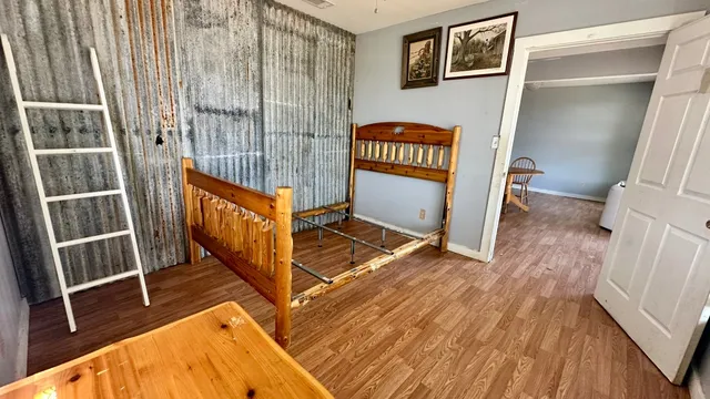 a view of a hallway with wooden floor and door