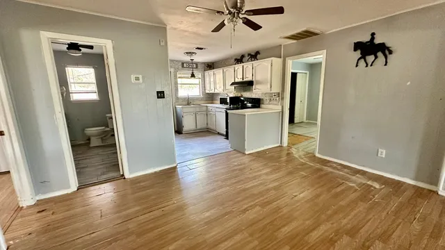 a view of a kitchen with a sink refrigerator and wooden floor