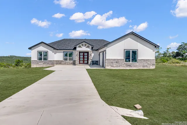 a front view of a house with a garden and yard