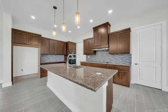a large kitchen with kitchen island a large counter top and wooden floors