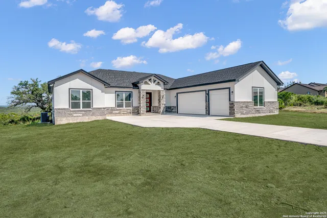 a front view of a house with a garden and yard