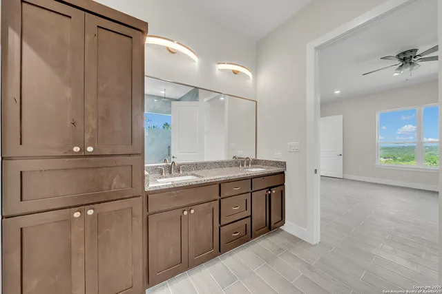 a bathroom with a granite countertop sink and a mirror