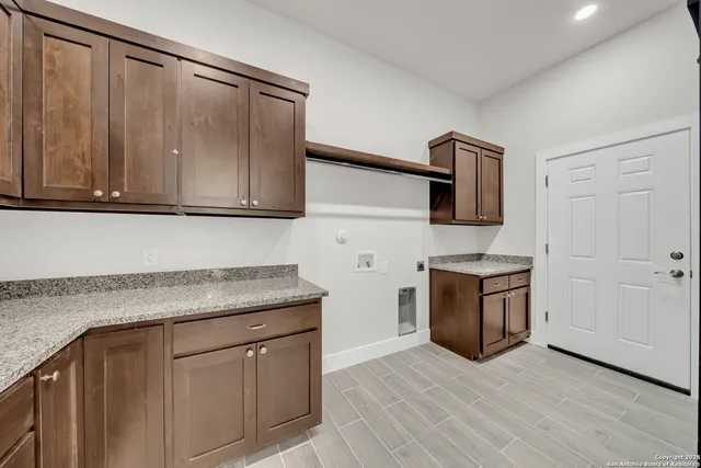 a kitchen with granite countertop a sink cabinets and stainless steel appliances