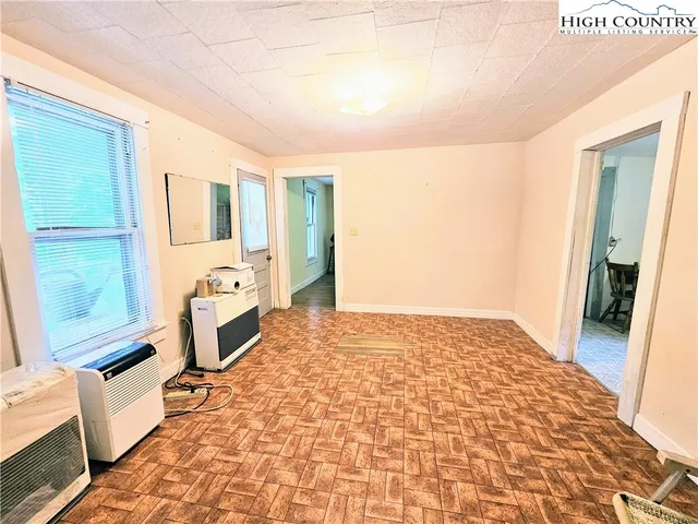 a spacious bedroom with a bed and wooden floor