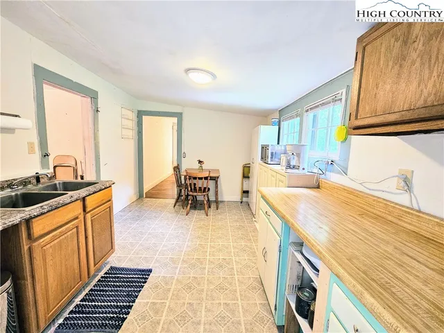 a dining hall with stainless steel appliances granite countertop a sink and a cabinets