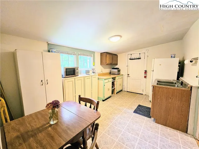 a kitchen with stainless steel appliances kitchen island granite countertop a refrigerator a stove a sink dishwasher and white cabinets with wooden floor