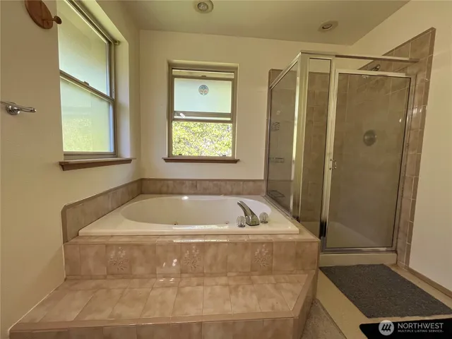 a view of an empty room with a window and a kitchen