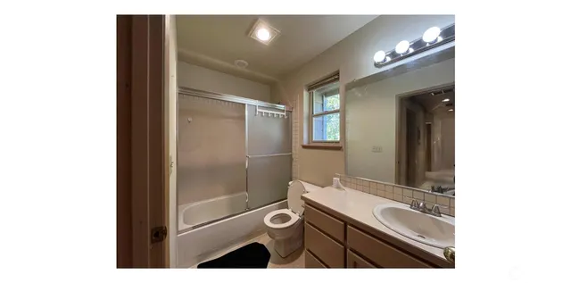 a view of backyard with a table and chairs a barbeque and a large trees