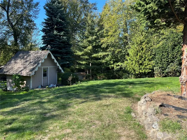 a view of a grassy field with trees in the background
