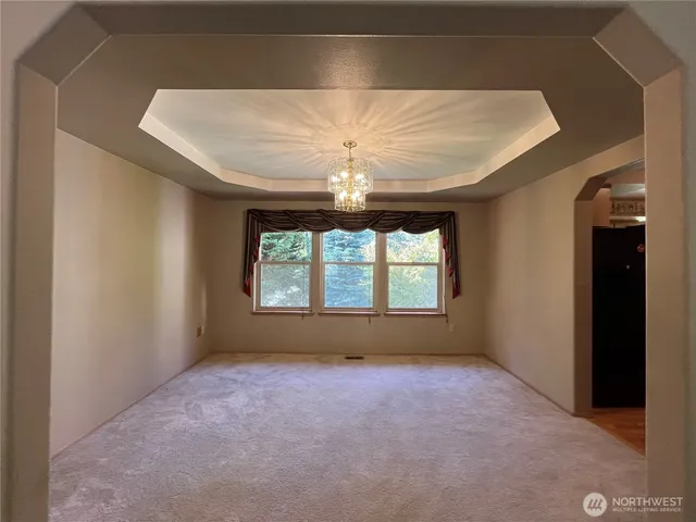 a view of a livingroom with a chandelier furniture and windows